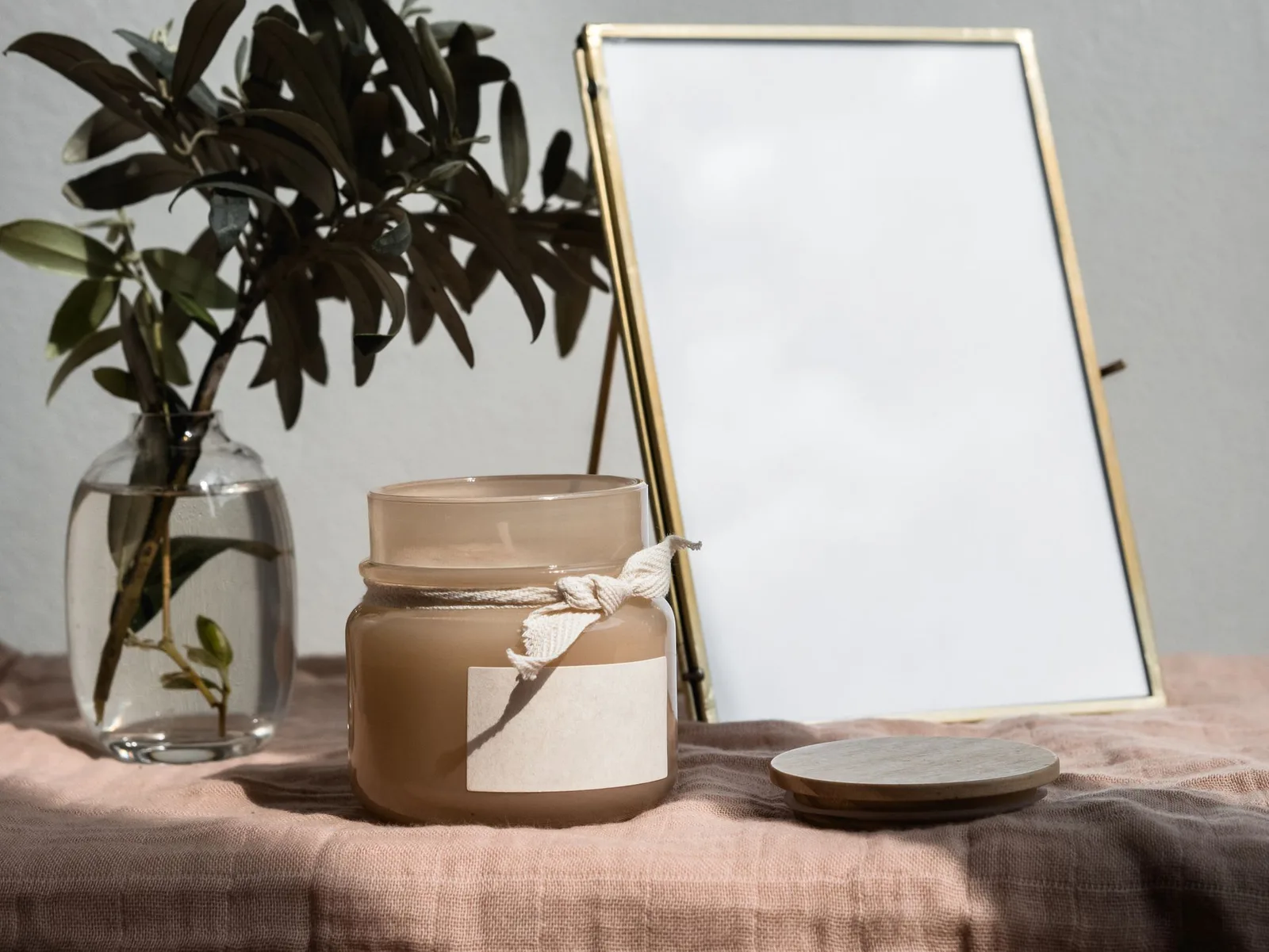 Lumânare parfumată, ramură de măslin și oglindă pe o masă — fotografie lifestyle pentru un magazin Home & Deco